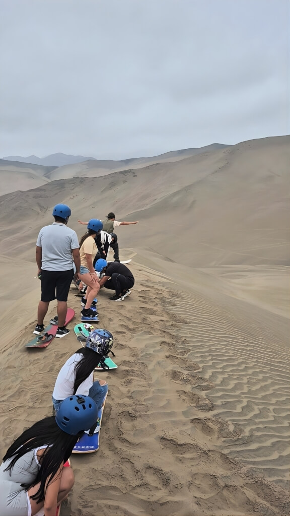 Grupo de visitantes explorando as dunas de Chilca